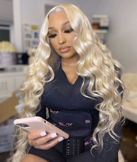 A person wearing a light gold long curly wig with voluminous big waves and long bangs.