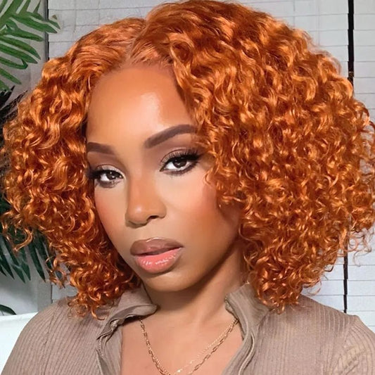Woman with vibrant orange curly hair wearing a beige jacket indoors.